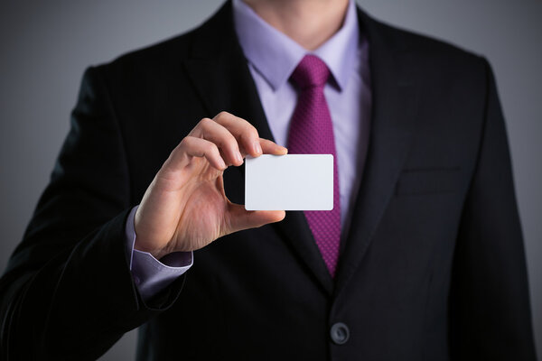 Business man showing a blank business card isolated, close up