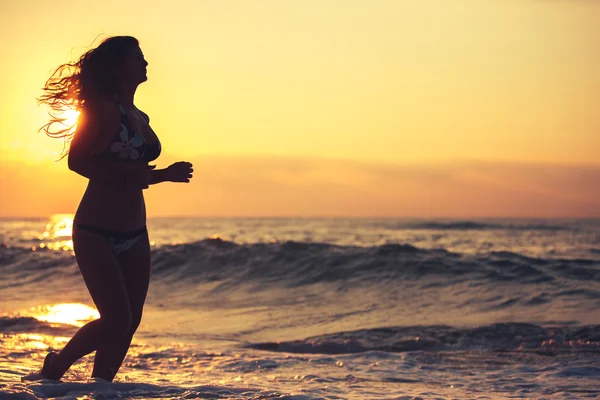 Silhouette einer unbeschwerten Frau am Strand — Stockfoto