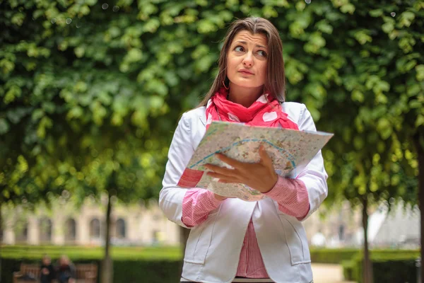Fiatal nő keresi a térképen, a City park, paris, Franciaország — Stock Fotó