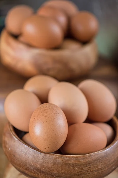 Свежие яйца на деревянной тарелке — стоковое фото