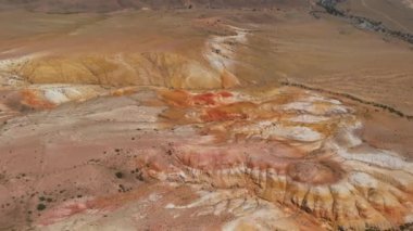 Mars 'ın yüzeyine benzeyen dokulu sarı ve kırmızı dağların havadan çekilmiş videosu.
