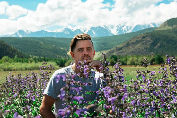 Homem em belo campo de flores rosa e roxo selvagem — Fotografia de Stock