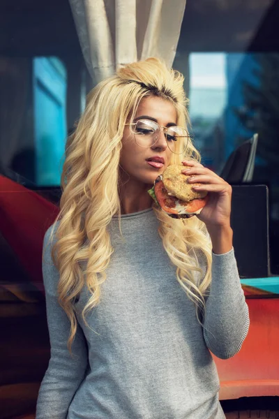 Žena jí hamburger a sodovku poblíž jídelního vozu — Stock fotografie