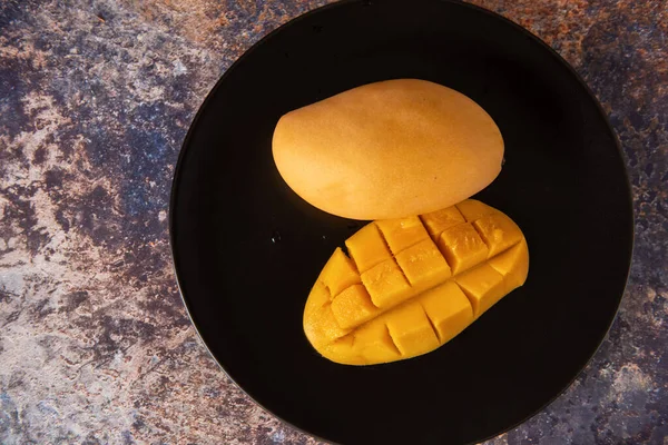 Siyah tabakta taze sarı mango meyvesi. — Stok fotoğraf