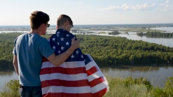 Cute young boy and his father holding aloft the American flag — Stock Video