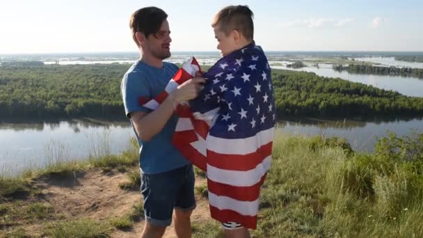 Netter kleiner Junge und sein Vater halten die amerikanische Flagge hoch — Stockvideo