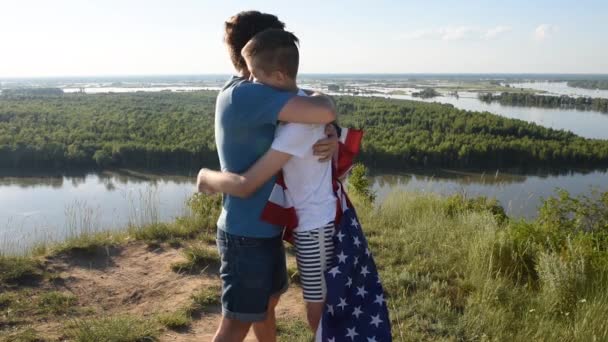 Carino giovane ragazzo e suo padre tenendo in alto la bandiera americana — Video Stock