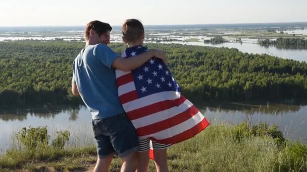 Schattige jonge jongen en zijn vader houden de Amerikaanse vlag omhoog — Stockvideo