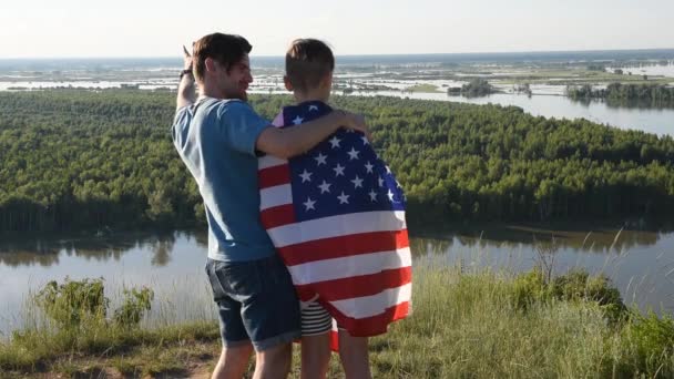 Schattige jonge jongen en zijn vader houden de Amerikaanse vlag omhoog — Stockvideo