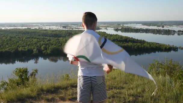 Menino acenando bandeira dos Jogos Olímpicos ao ar livre — Vídeo de Stock