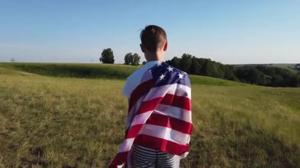 Ragazzo sventola bandiera nazionale degli Stati Uniti all'aperto sopra il cielo blu sulla riva del fiume — Video Stock