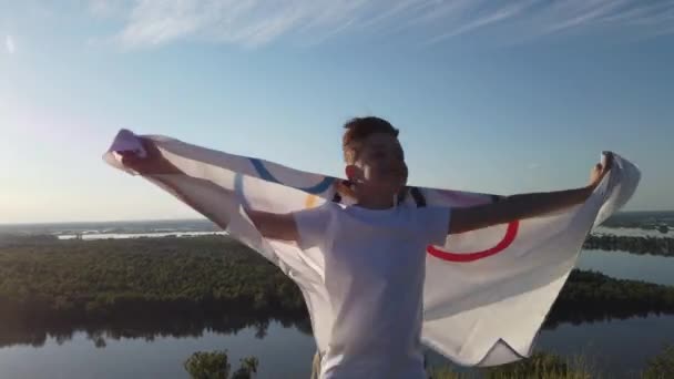 Niño ondeando bandera de los Juegos Olímpicos al aire libre — Vídeo de stock