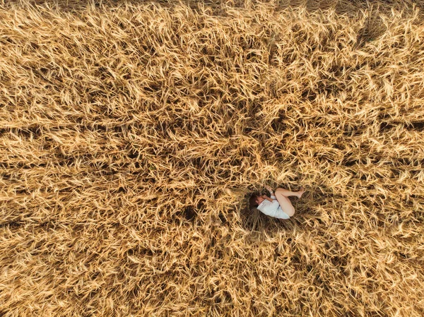 Vue aérienne de la femme couchée dans le champ de blé — Photo