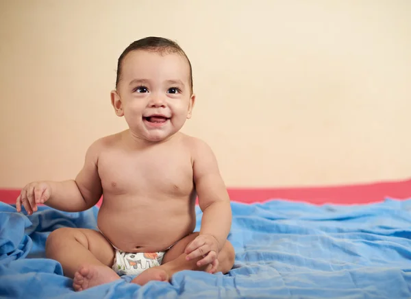 Baby auf dem Bett sitzen Stockbild