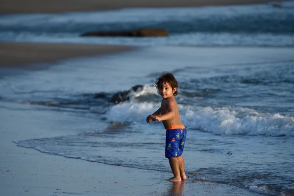 Niño pequeño jugar en la costa del océano —  Fotos de Stock
