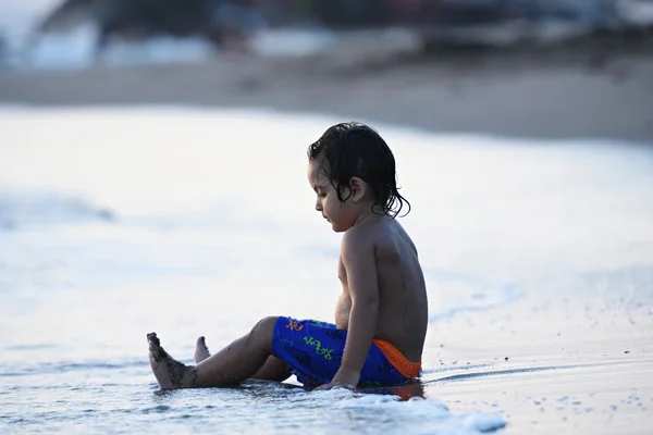 Niño sentarse en la playa de arena —  Fotos de Stock