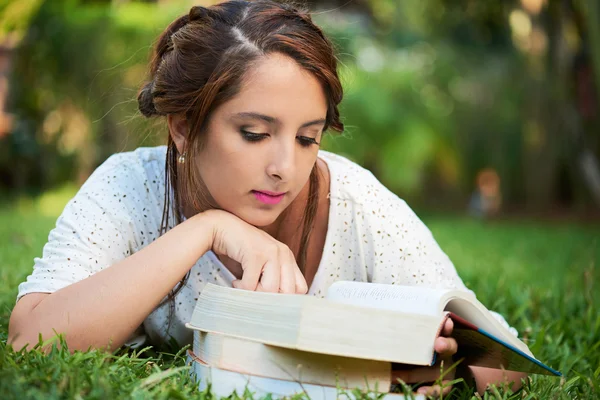 Chica que pone mientras lee —  Fotos de Stock