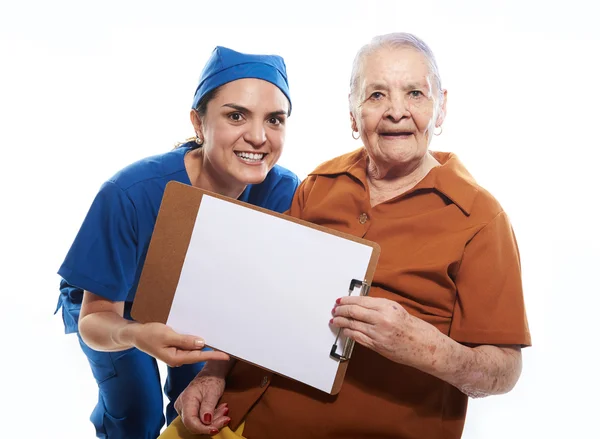 Enfermeira e mulher idosa segurar bordo — Fotografia de Stock