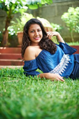 Kız çimlerin üzerinde yatıyor.