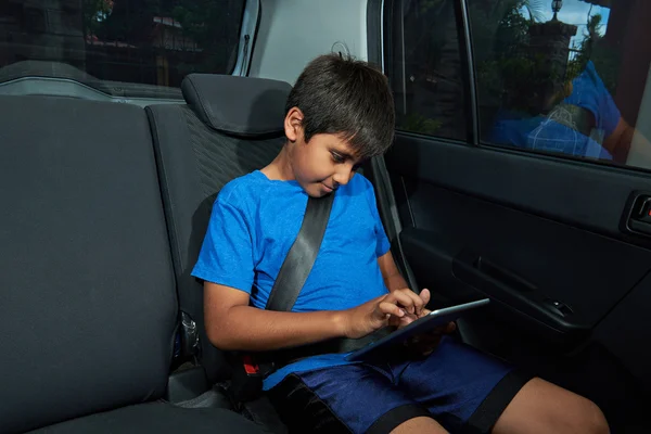 Chlapec s tablet na zadním sedadle — Stock fotografie
