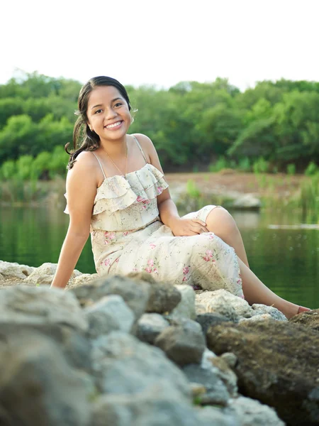 Girl sitting on rocks — Stock Photo, Image