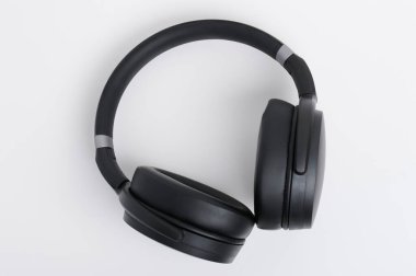 Üst manzaranın üzerinde beyaz arka planda izole siyah deri kulaklıklar.