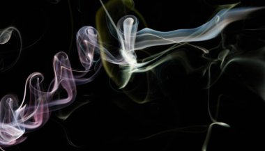 Pembe ve sarı duman çizgileri siyah izole arkaplanda dönüyor