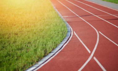 Güneşli bir günde çimlerle koşu pistini açın.