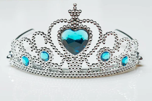 Silver crown with blue gems isolated on studio background