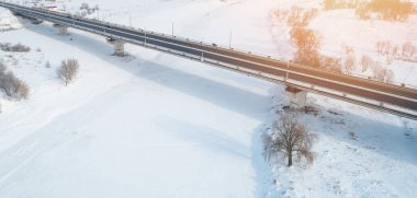 Donmuş nehir hava aracı görüntüsü üzerinde bir araba köprüsü. Kış taşımacılığı teması