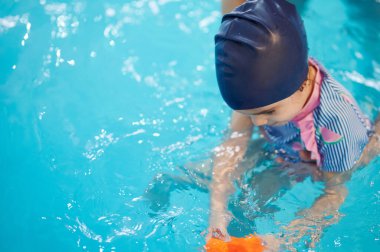 Oyuncak çocukla yüzme havuzunun arka planında oynamak.