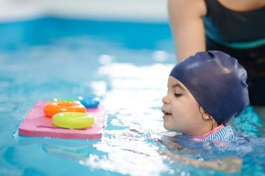 Çocuk için anaokulunda yüzme egzersizi mavi su arka planında