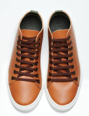 Beyaz stüdyo arka planında izole edilmiş çift kahverengi spor ayakkabısının perspektif görüntüsü