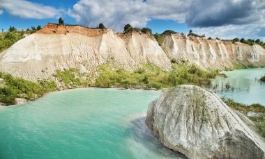 Güneşli bir günde yeşil su manzaralı büyük bir taş ocağı.