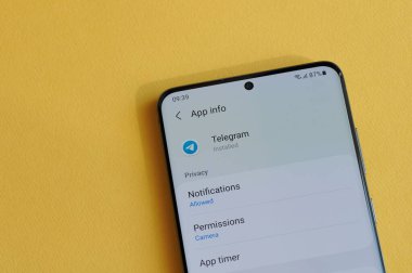 New York, ABD - 12 Nisan 2021: Sarı arka plandaki akıllı telefon ekranında telgraf uygulamasında gizlilik ayarının değiştirilmesi