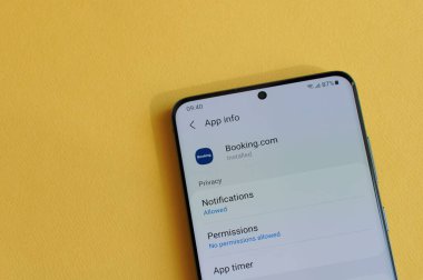 New York, ABD - 12 Nisan 2021: Sarı arka plandaki akıllı telefon ekranında yer ayırtma uygulamasında gizlilik ayarları değiştiriliyor