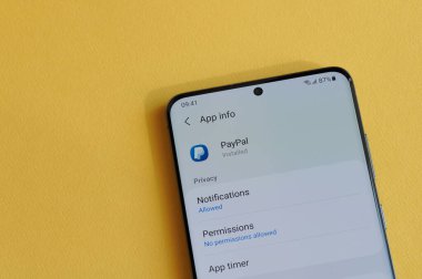 New York, ABD - 12 Nisan 2021: Sarı arka plandaki akıllı telefon ekranında Paypal uygulamasında gizlilik ayarları değiştiriliyor