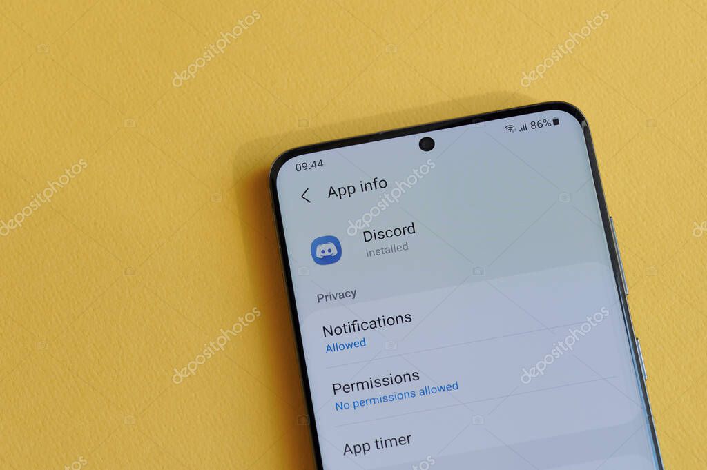 New york, USA - April 12, 2021: Changing privacy setting in discord app on smartphone screen in yellow background