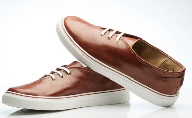 Stüdyo arka planında izole edilmiş zarif kahverengi deri ayakkabılar.