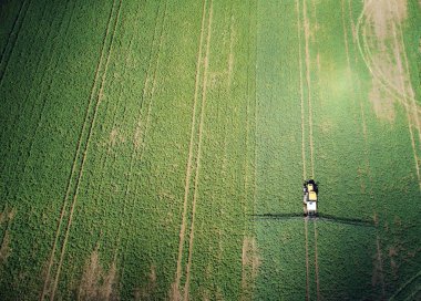 Tarım yeşil alanı traktörle İHA üst görüşü üzerinde kimyasallar uygula