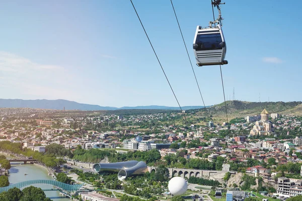 Sightseeing cable car move over Tbilisi city on bright sunny day