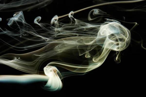 Abstract elegant smoke swirls yellow color on black background. Elegant colorful curves wallpaper