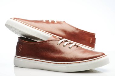 Bir çift kahverengi, beyaz bağcıklı ve tek izole ayakkabılar.