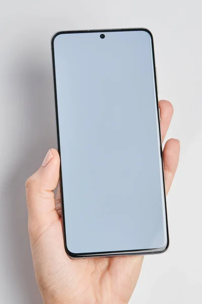 クリーンな白い画面で手に現代のスマートフォンを閉じビューを隔離 — ストック写真