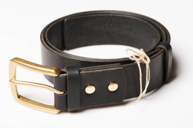 Beyaz stüdyo arka planında izole edilmiş yuvarlak siyah deri kemer.