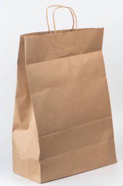 Sağlam kahverengi kağıt torba ayakta duruyor, alışverişe ya da hediyelere hazır, pratik tasarım ve tutamaklarını gösteriyor.