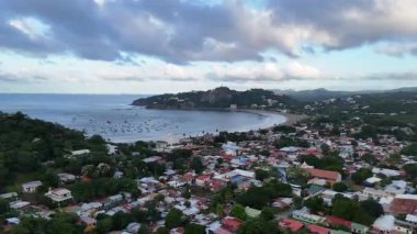 San Juan del Sur 'un güzel panoramik manzarası, güneş ufukta batarken sahili, tekneleri ve canlı kasabayı gösteriyor..
