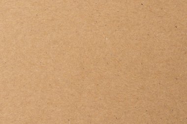 Gündüz vakti çalışma ortamında çeşitli zanaat faaliyetleri ve ambalaj gereksinimleri için kullanılan düz bir yüzey üzerinde düz kahverengi kağıt.