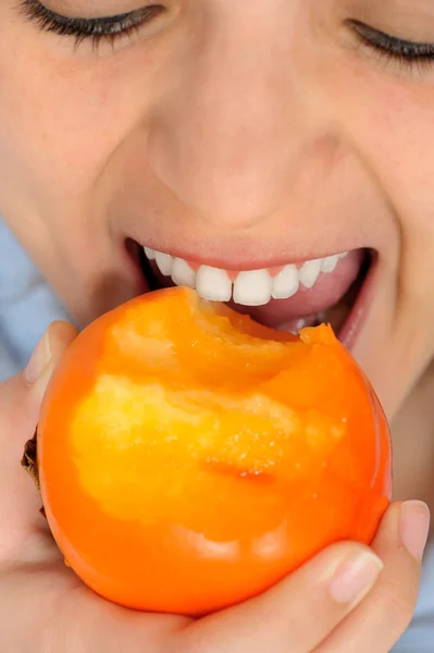 Girl Eating persimmon — Stock Photo, Image
