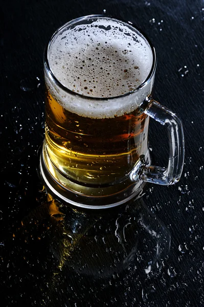 Стеклянное пиво на мокром столе — стоковое фото